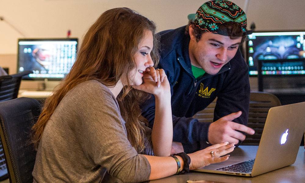 Two Wilkes students work on laptop
