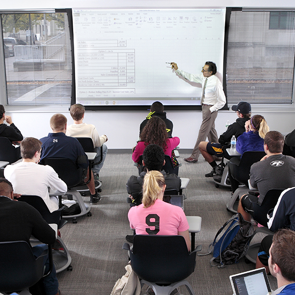a professor leading a class using a smart board