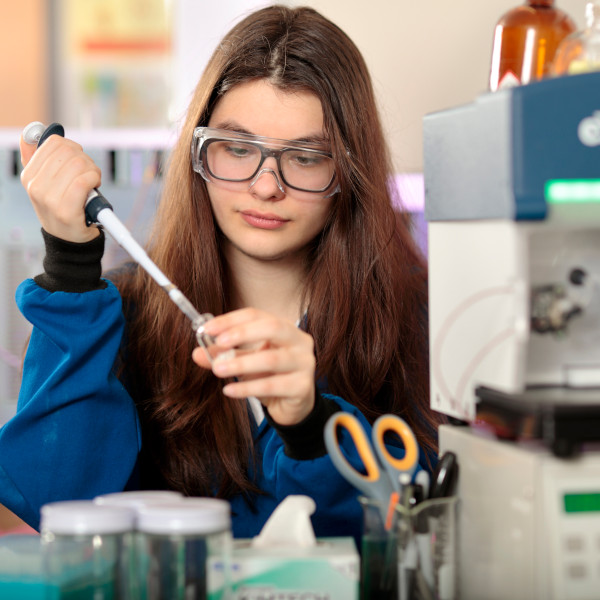 a female student performing a chemistry experiment in a lab