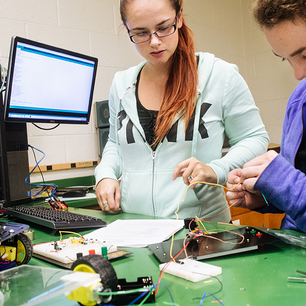 two female students building a robot rover