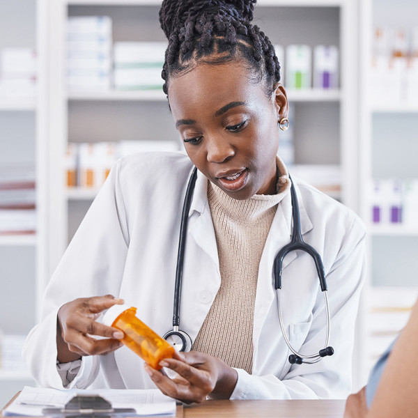 A healthcare professional describing a bottle of medication to a patient