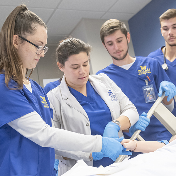 a group of nursing students working in a simulation lab