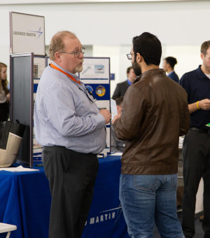 A student speaks with a representative from Lockeed Martin at the Career Fair