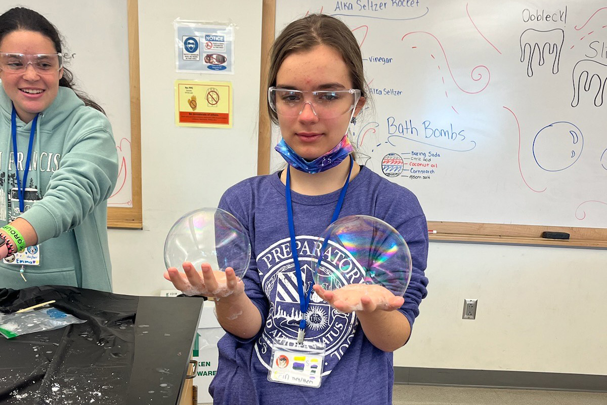Student holds bubbles as part of a WEBS experiment activity